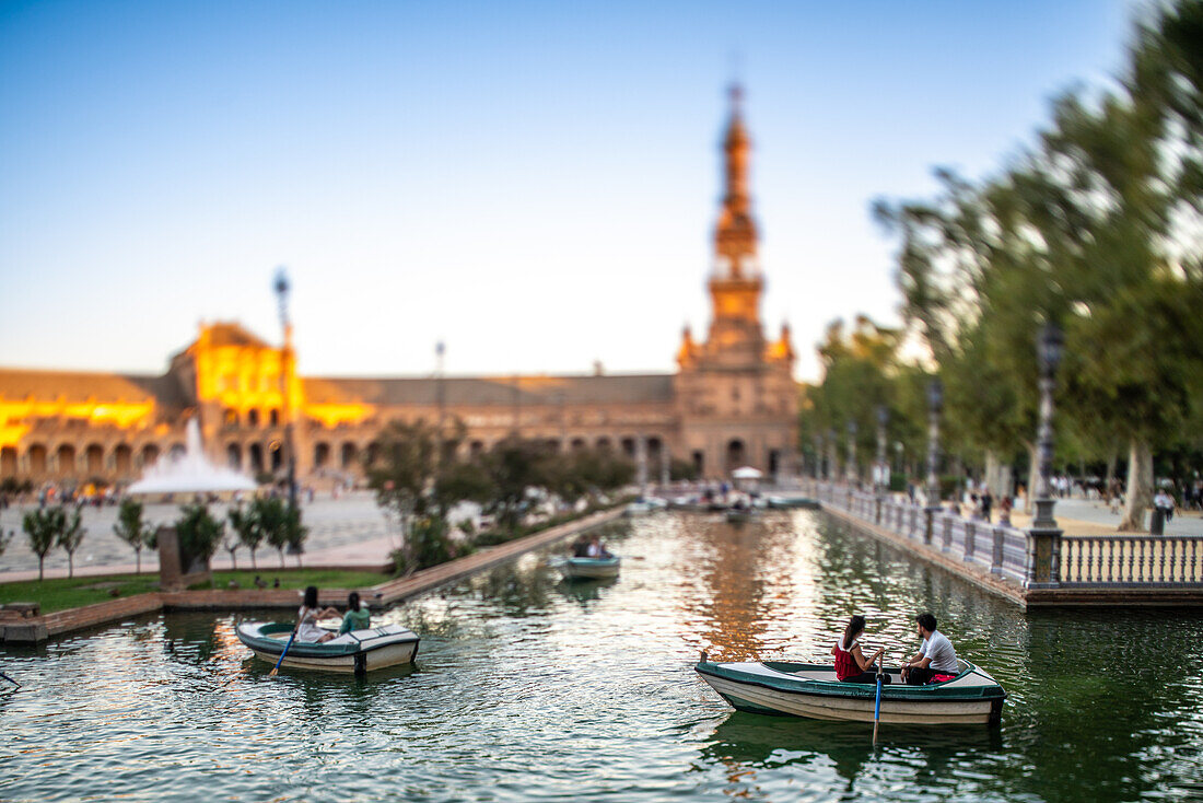 Heitere Abendansicht von Bootsfahrern auf der Plaza de Espana in Sevilla, Spanien, aufgenommen mit einem Tilt-Shift-Effekt.