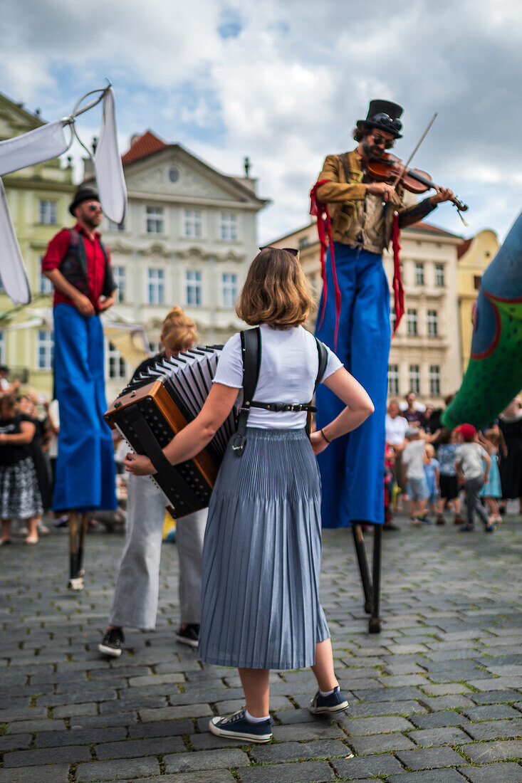 Artist plays violin while walking on stilts at the Parade of puppets from Marián Square to Old Town Square during the Prague Street Theatre Festival Behind the Door, Prague, Czech Republic