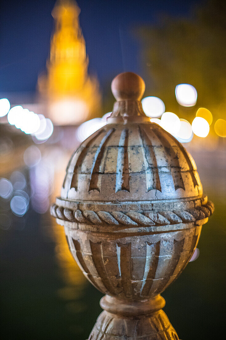 Close up view of a historic architectural detail at Plaza de Espana in Seville, Spain, captured at night with beautiful bokeh lights.