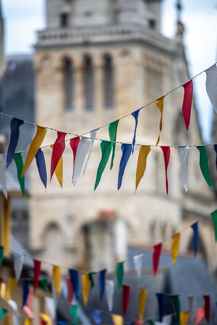 Colorful festival flags hanging with a historical background in Vannes, Brittany, France. Perfect summer celebration in a beautiful French city.