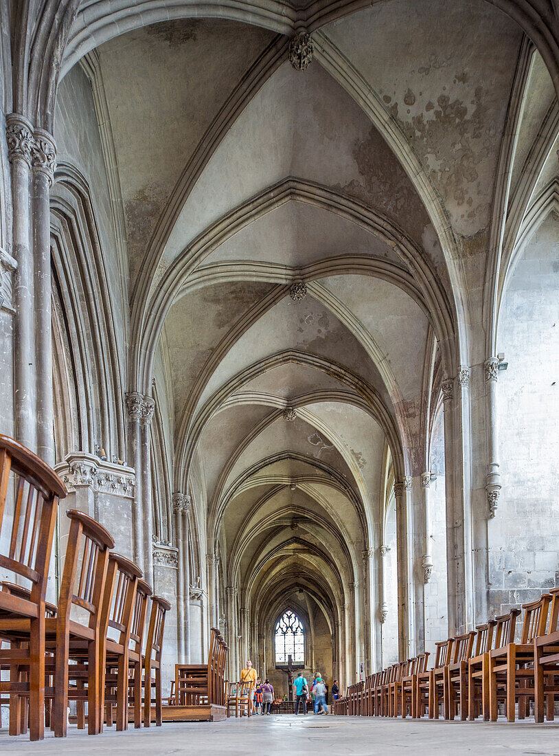 Majestätische Innenansicht der Eglise Saint Pierre in Caen, Normandie, Frankreich. Menschen spazieren durch die historische gotische Architektur.