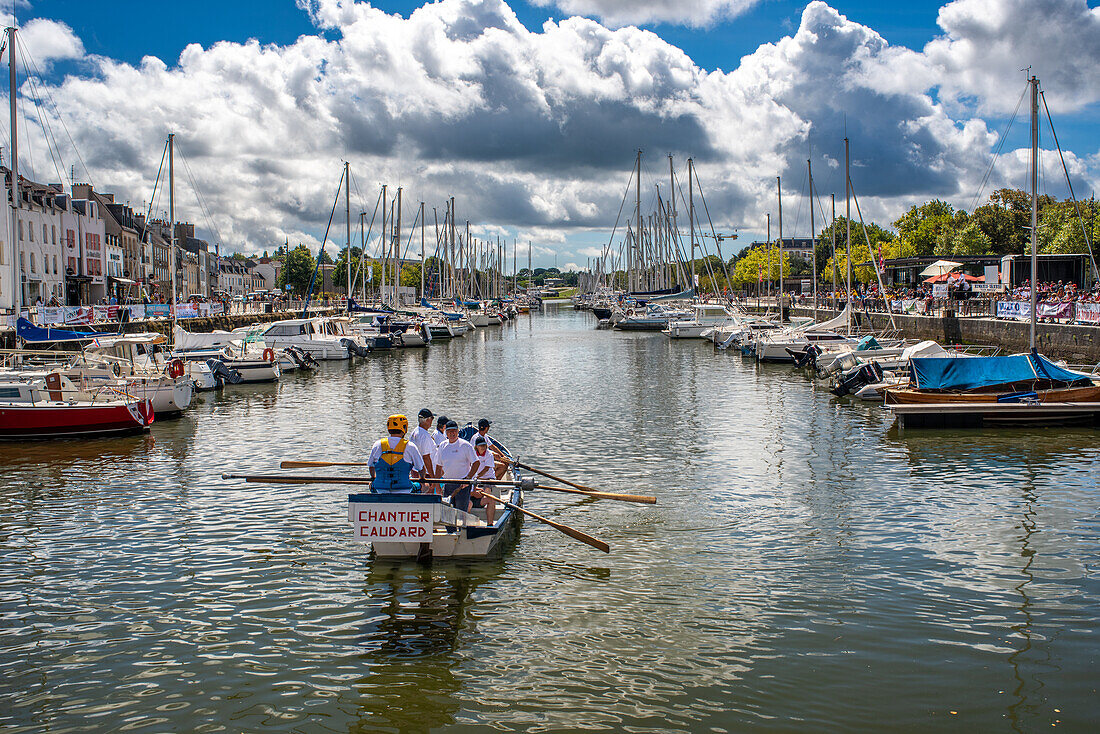 Teilnehmer rudern ein Boot während eines Bootsrennens im malerischen Hafen von Vannes in der Bretagne, Frankreich.