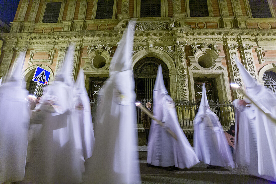 Nazarener der Cofradia del Resucitado bei der Verarbeitung vor der barocken Fassade von San Luis de los Franceses in Sevilla während der Semana Santa.