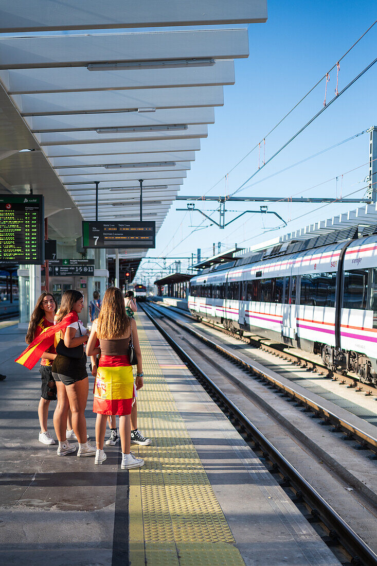 Spanische Fans warten auf den Zug, um an den Straßenfeiern in Madrid teilzunehmen, nachdem der Europameister Spanien 2024 mit einem königlichen Empfang nach Hause zurückgekehrt ist, Madrid