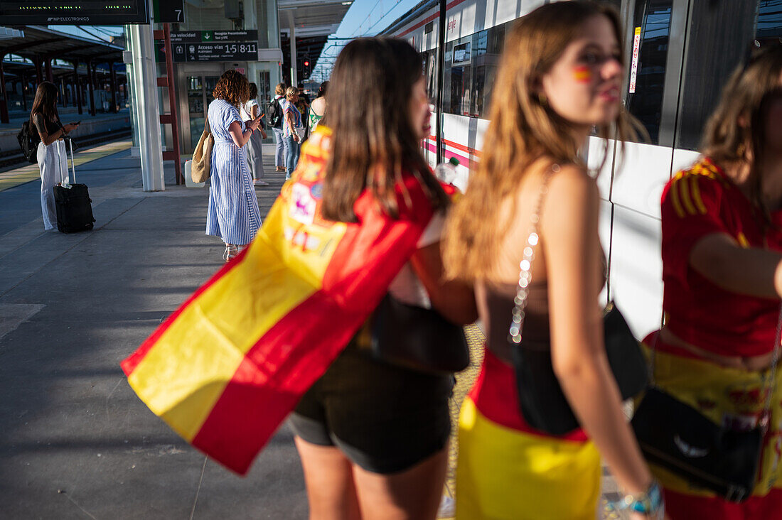 Spanische Fans warten auf den Zug, um an den Straßenfesten in Madrid teilzunehmen, nachdem der Europameister Spanien 2024 mit einem königlichen Empfang nach Hause zurückgekehrt ist, Madrid