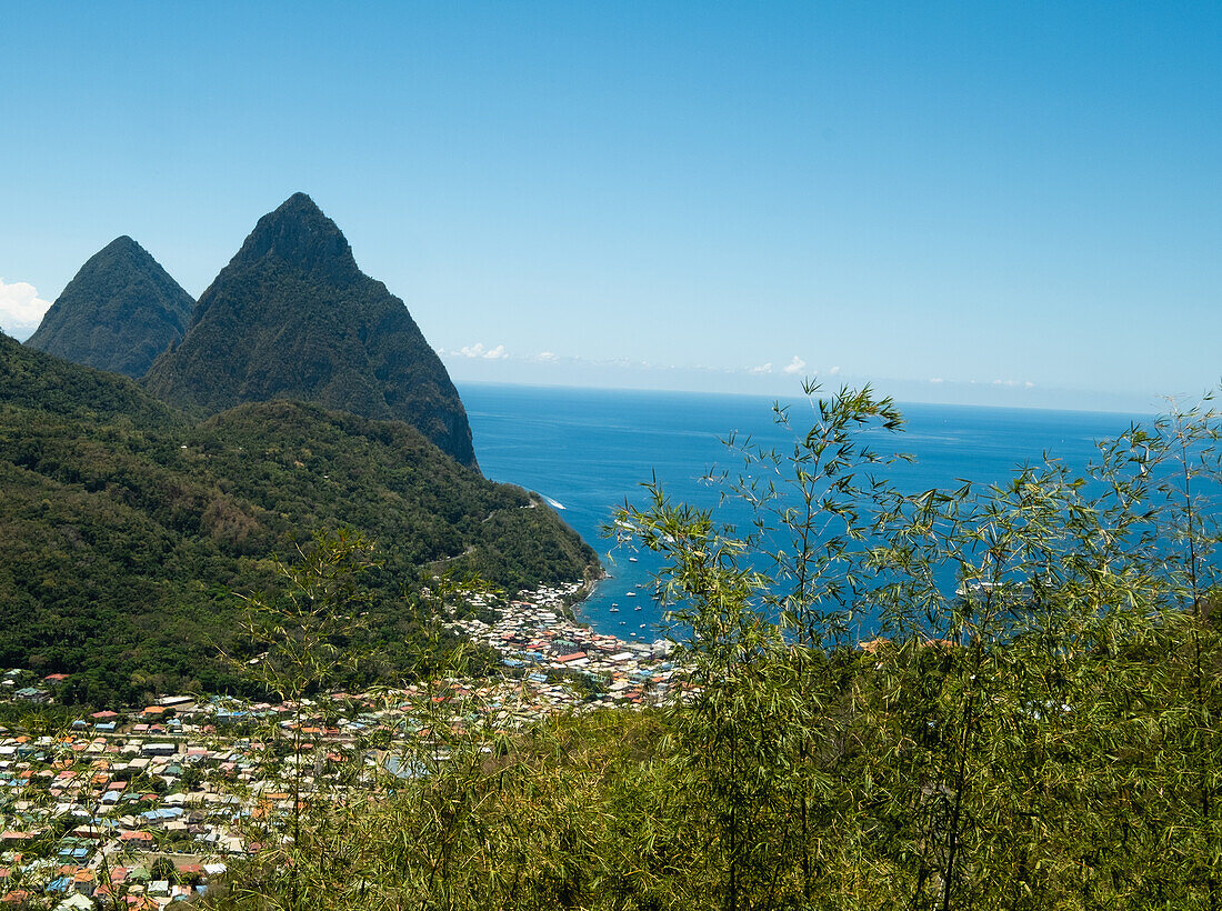 Stadt in Hügellandschaft mit Meer im Hintergrund