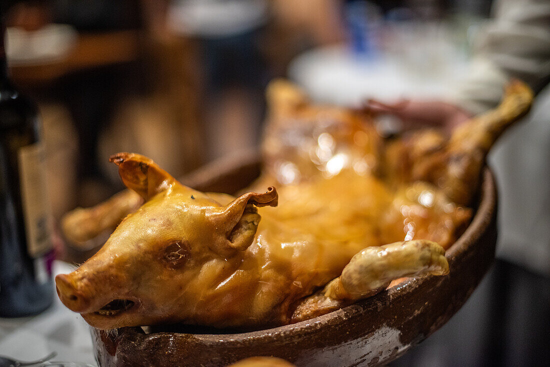 Köstliches und traditionelles Gericht mit gebratenem Ferkel, bekannt als Cochinillo Al Horno, eine kulinarische Spezialität aus Segovia, Castilla y Leon, Spanien.