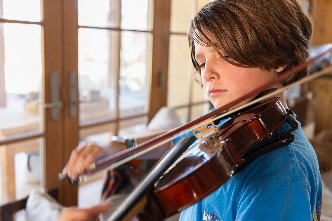 Boy playing violin at home