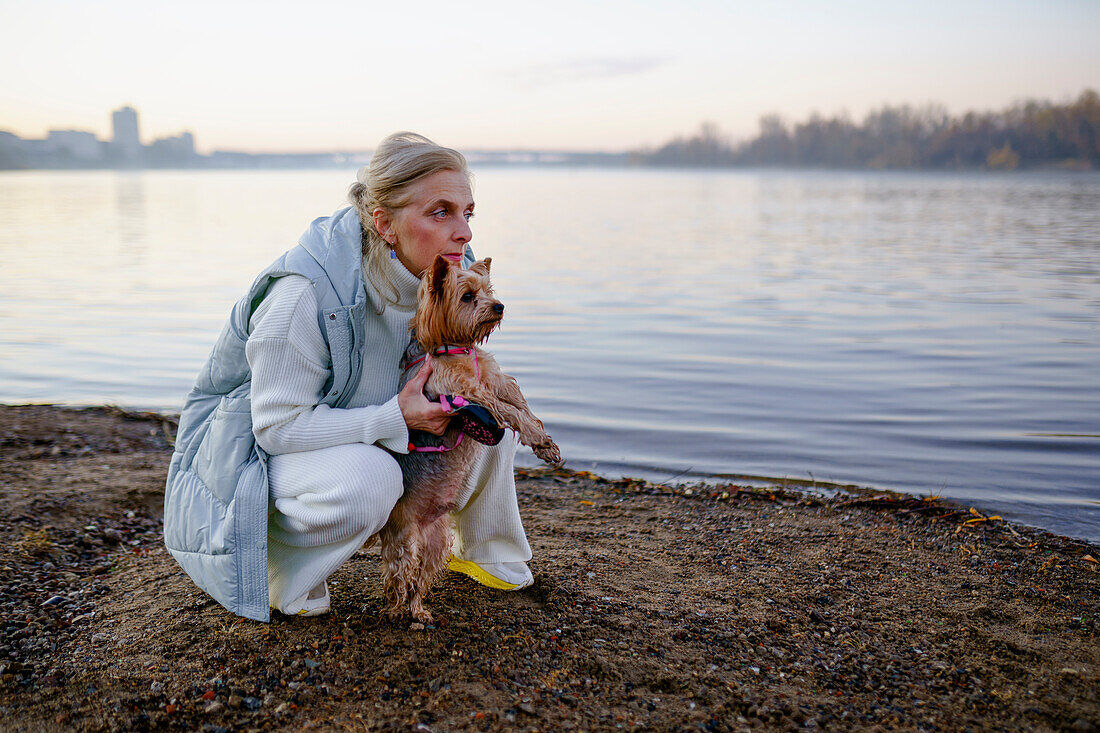 Frau mit Yorkshire Terrier am Seeufer