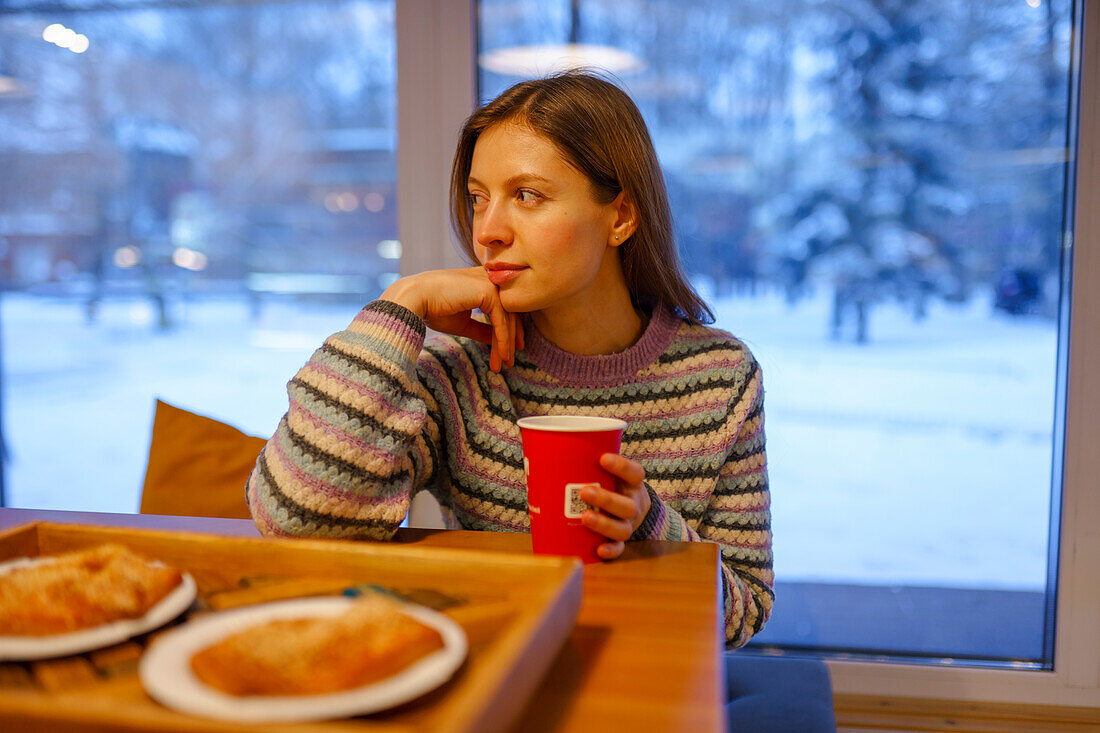 Porträt einer Frau beim Frühstück im Cafe