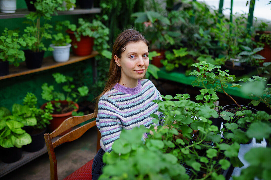 Portrait of woman standing in greenhouse