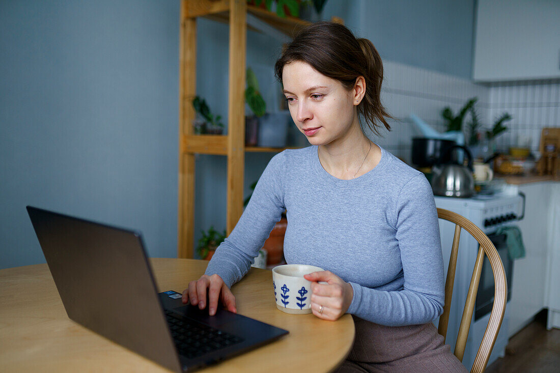 Frau benutzt Laptop zu Hause