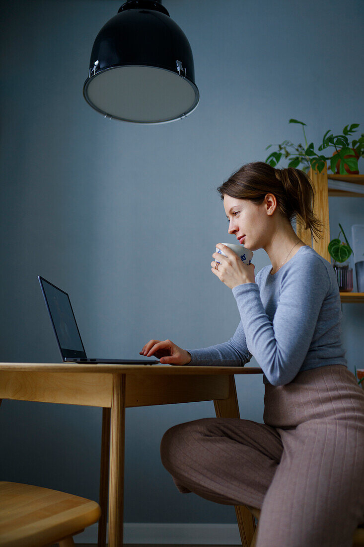 Frau benutzt Laptop zu Hause