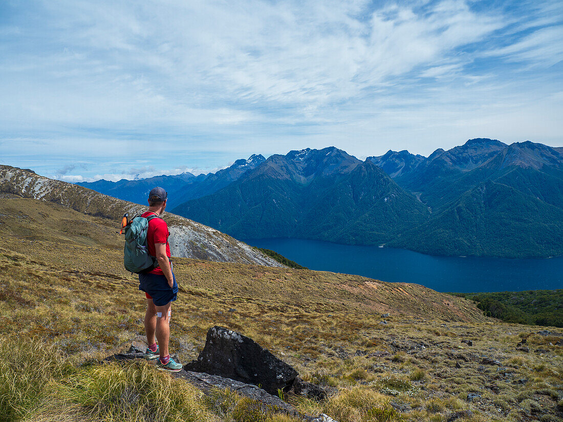 Wanderer mit Blick auf Fjord und Berge im Fiordland-Nationalpark