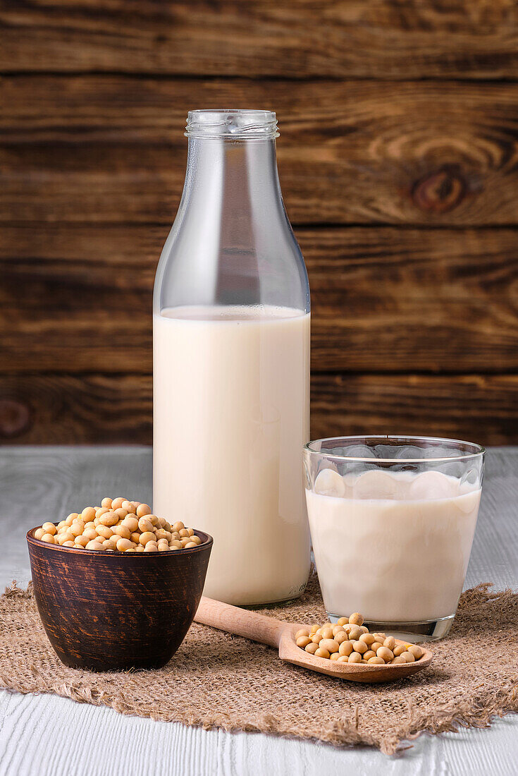 Sojamilch mit Sojabohnen, Flasche und Glas