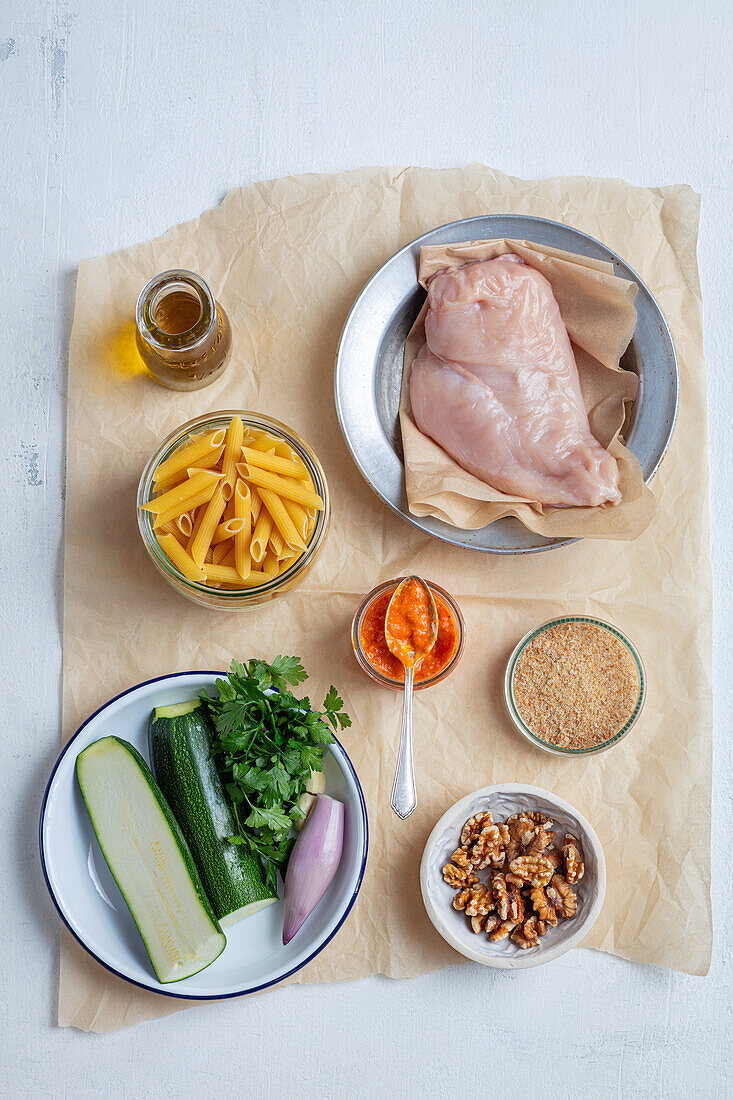 Ingredients for chicken casserole with penne, zucchini and walnuts