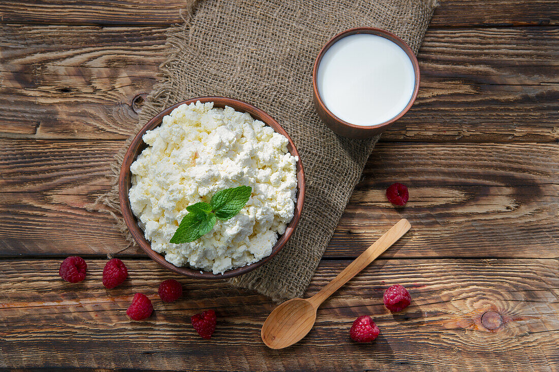 Körniger Frischkäse und Milch mit Himbeeren