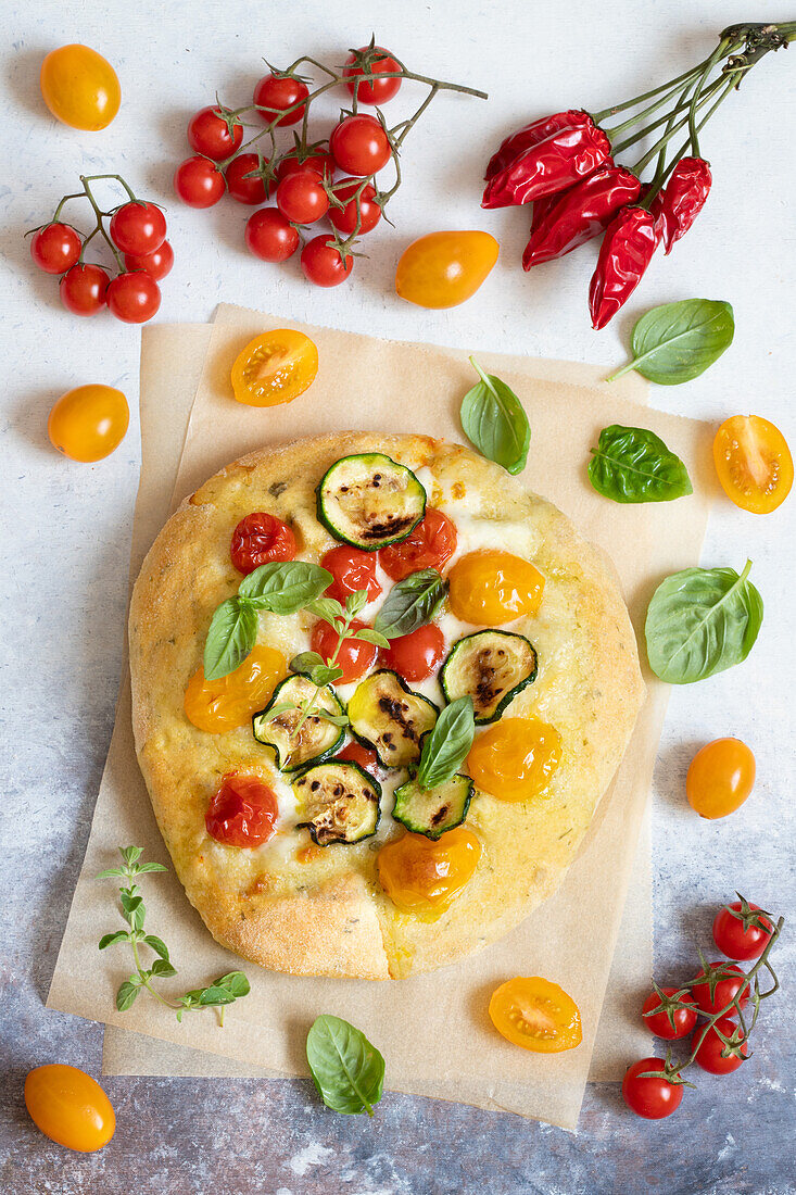 Pizza with tomatoes, mozzarella and courgette