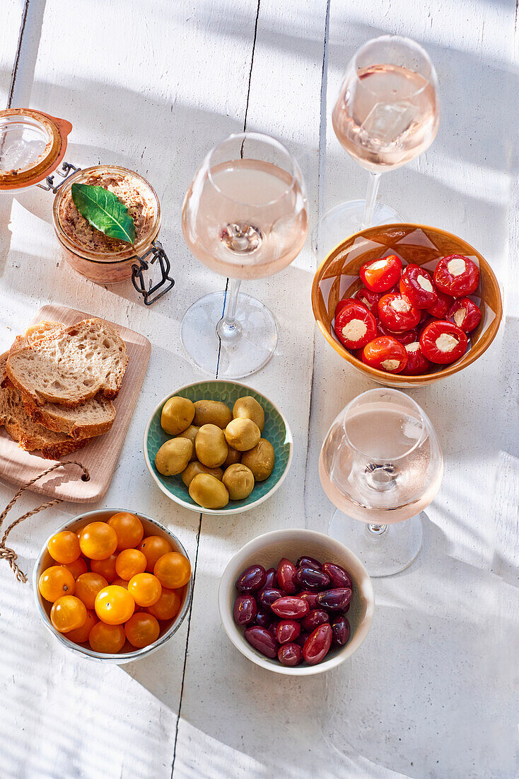 Tapas platter with olives, peppers, bread, rillettes and rosé wine