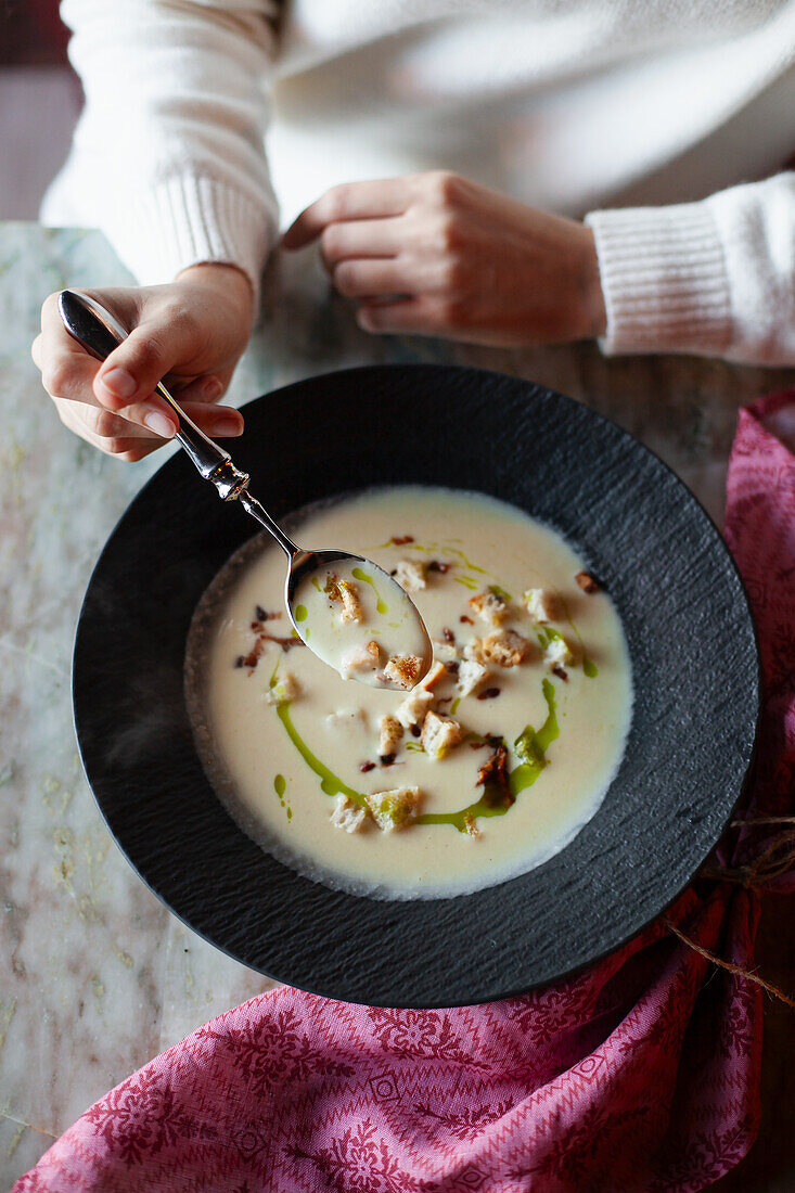 Cheese soup with croutons, bacon and chive oil