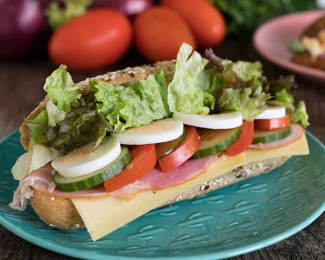 Sandwich mit Schinken, Käse und Gemüse