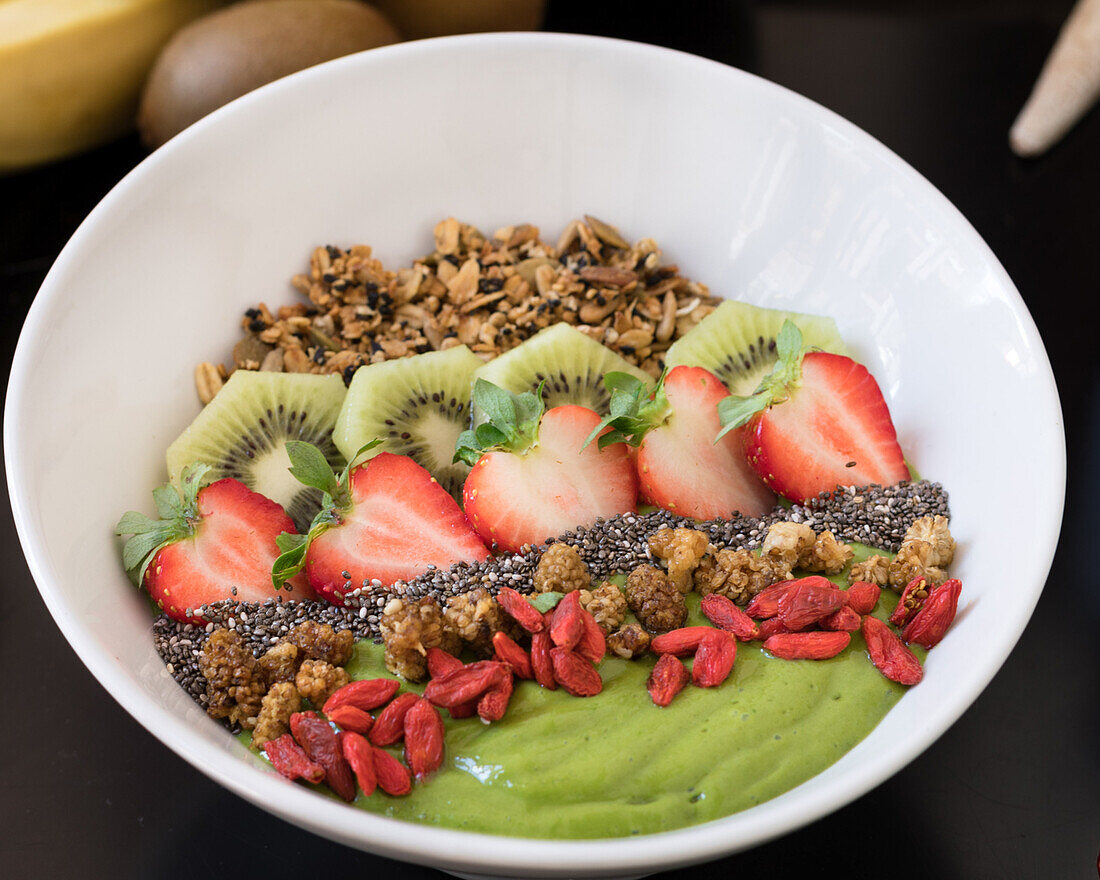 Frühstücksbowl mit Erdbeeren, Kiwi, Granola und Gojibeeren