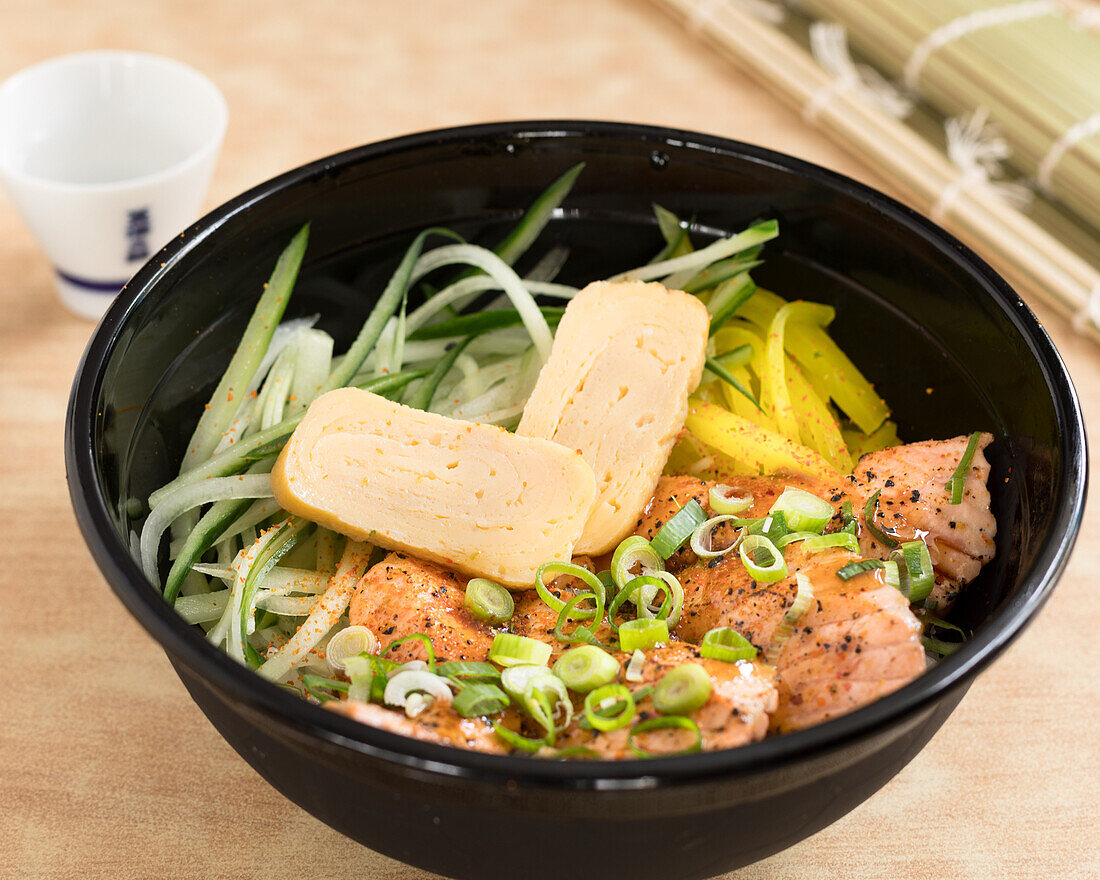 Bento box with salmon, vegetables and egg garnish