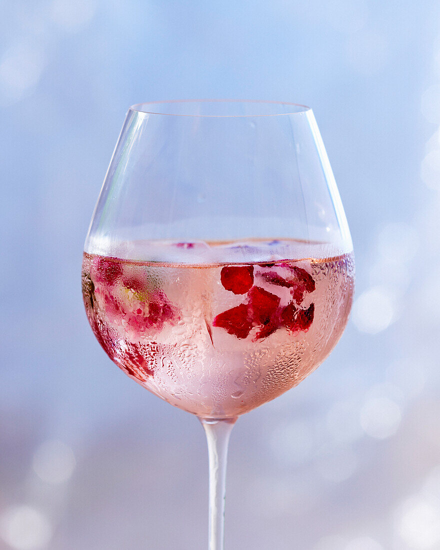 Rosé wine with edible flowers and ice cubes