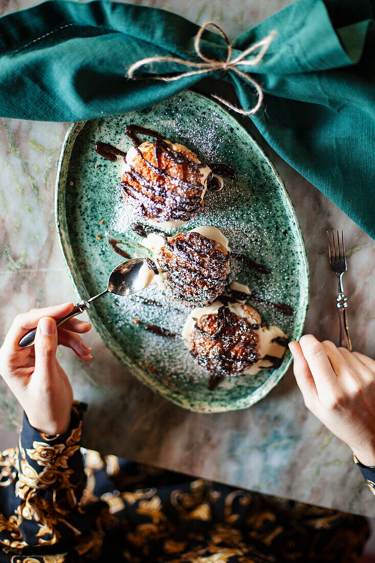 Profiteroles mit Schokoladensauce und Puderzucker