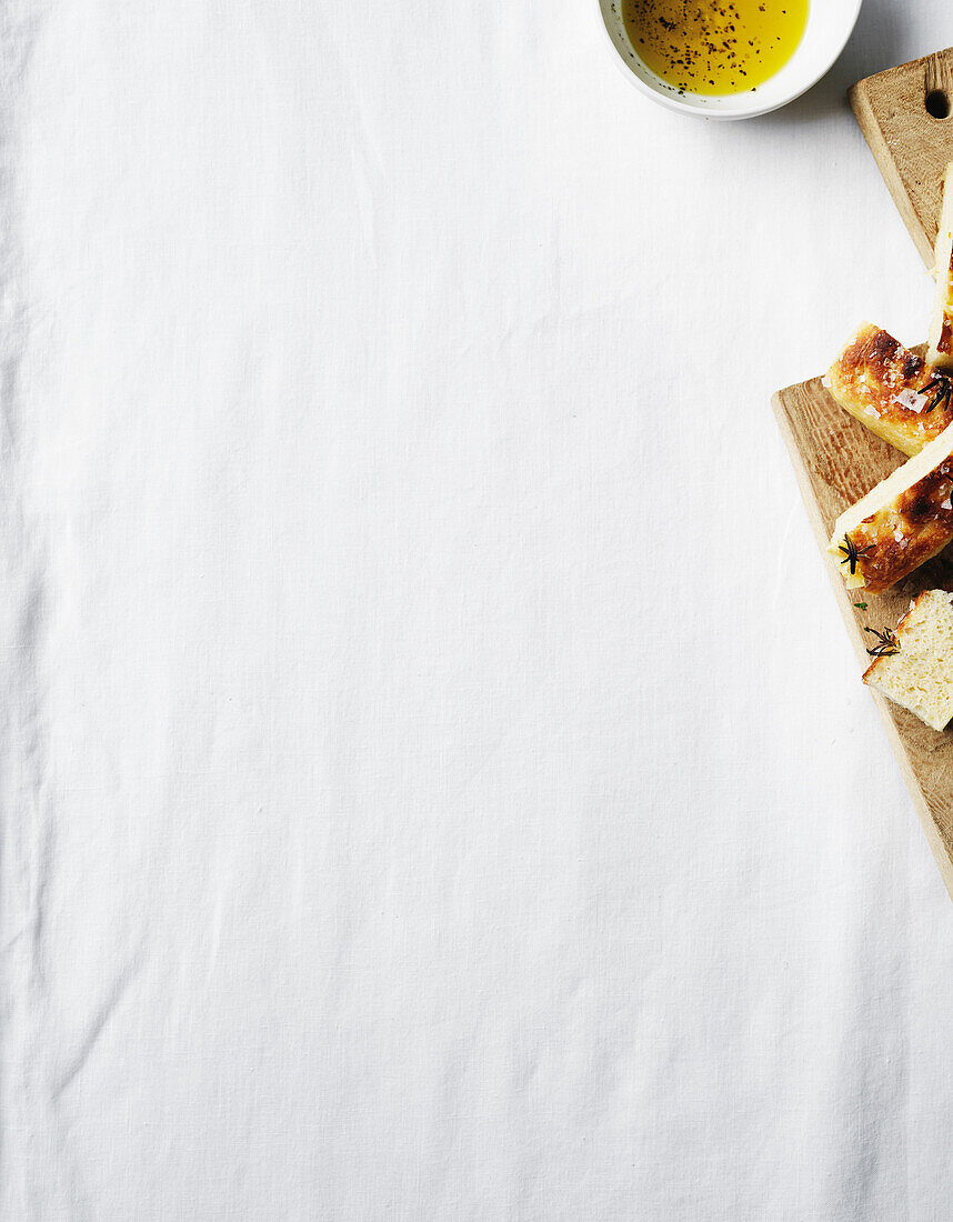 Focaccia with olive oil and herbs on a white background