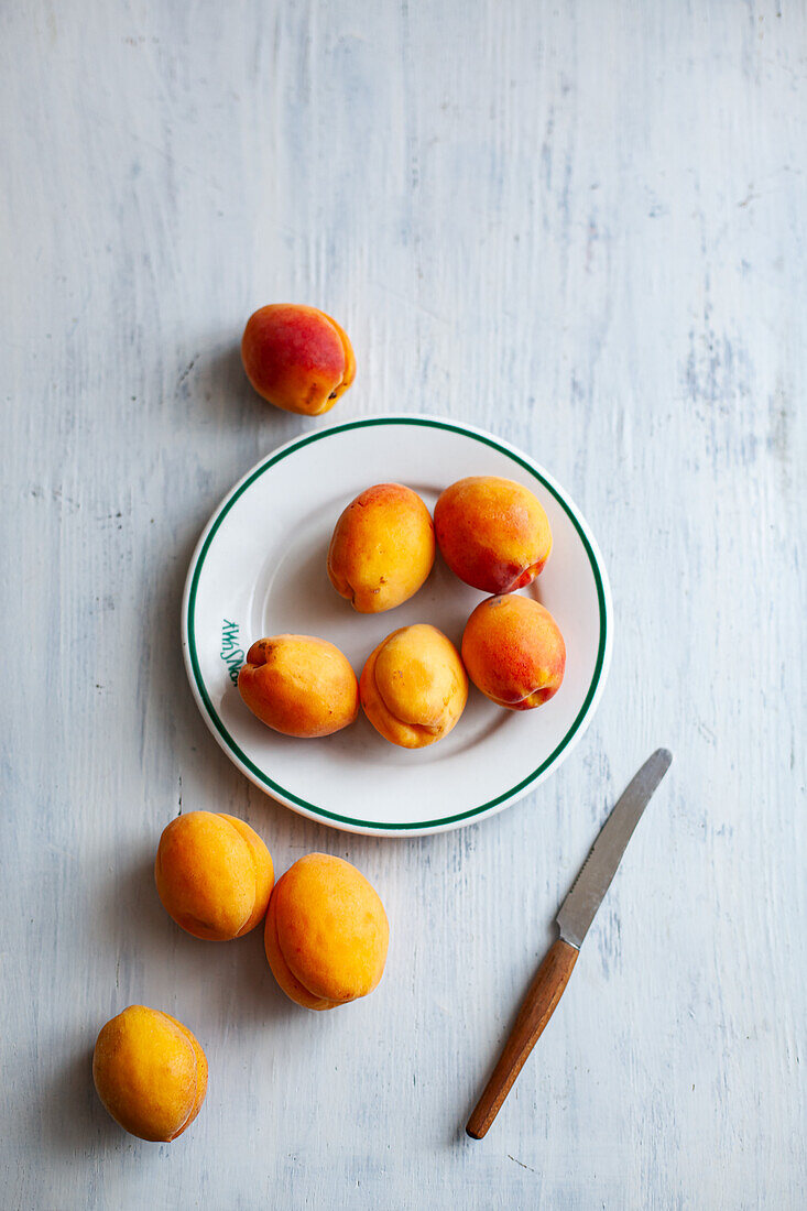 Ripe apricots on a plate with a knife