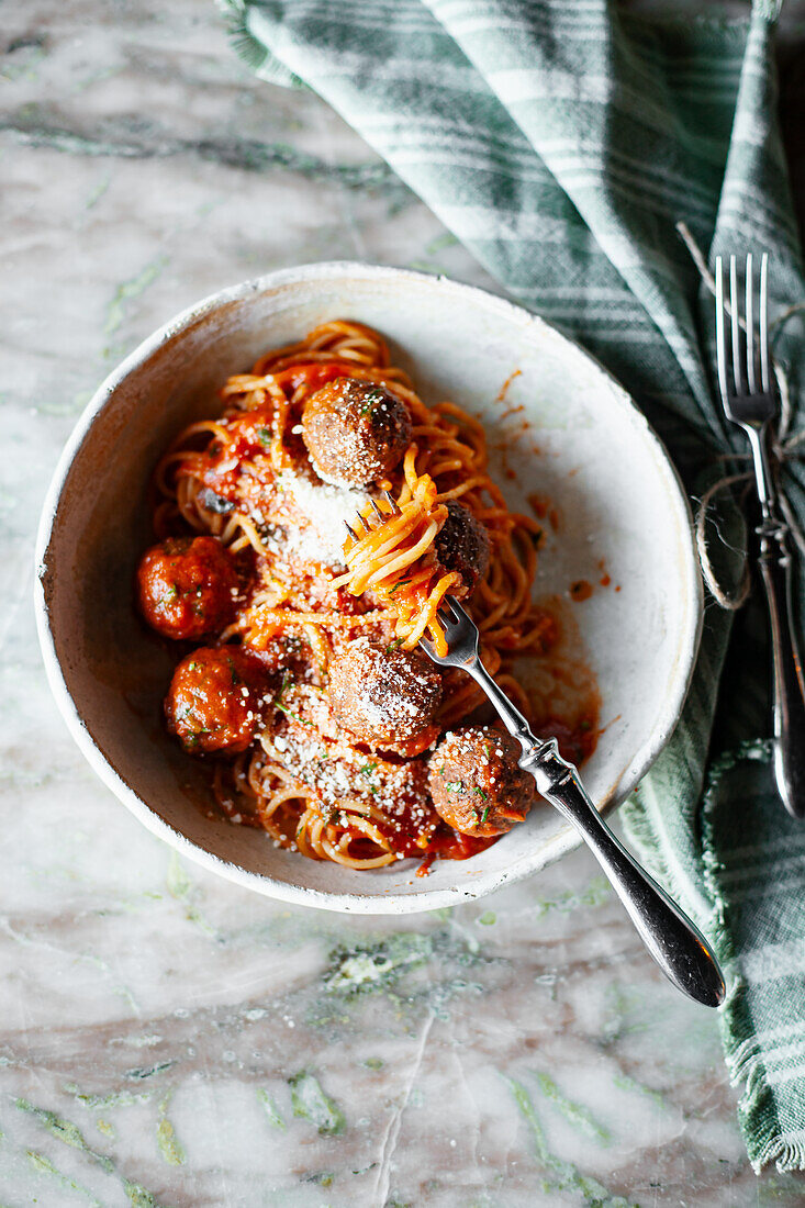 Spaghetti mit Fleischbällchen in Tomatensoße und geriebenem Parmesan