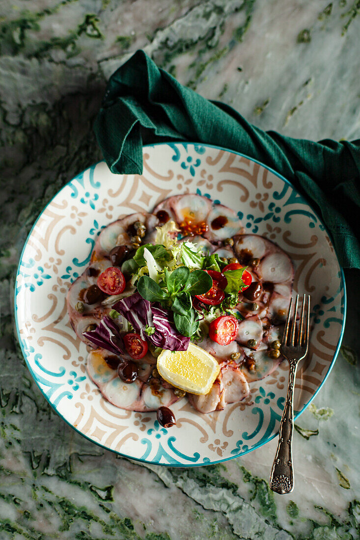 Oktopus-Carpaccio mit Zitrone und Salat