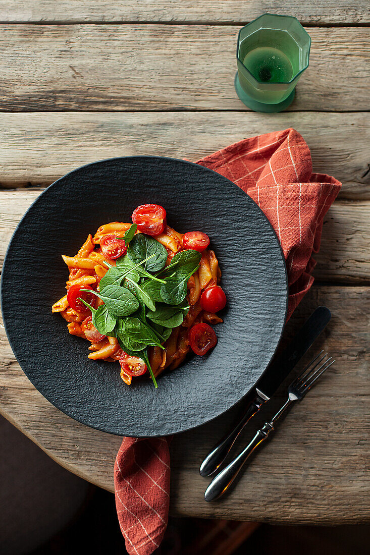 Penne in Käsesauce mit Kirschtomaten und Spinatblättern