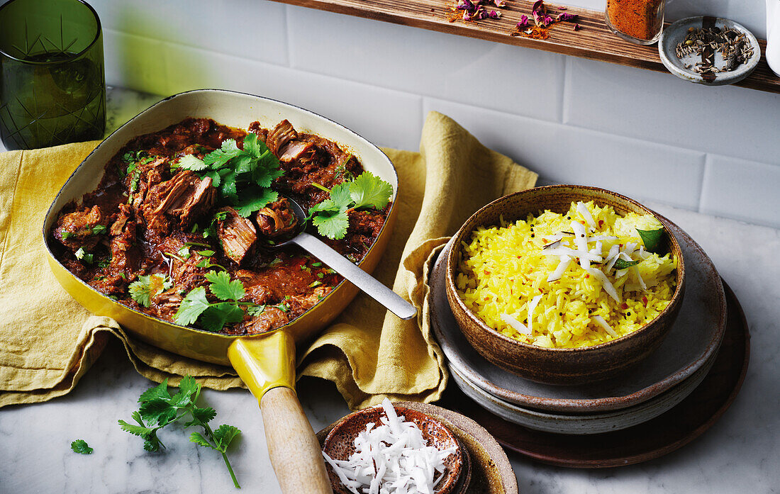 Gelber Zitronenreis mit kräftigem Lammcurry und Kokosraspeln