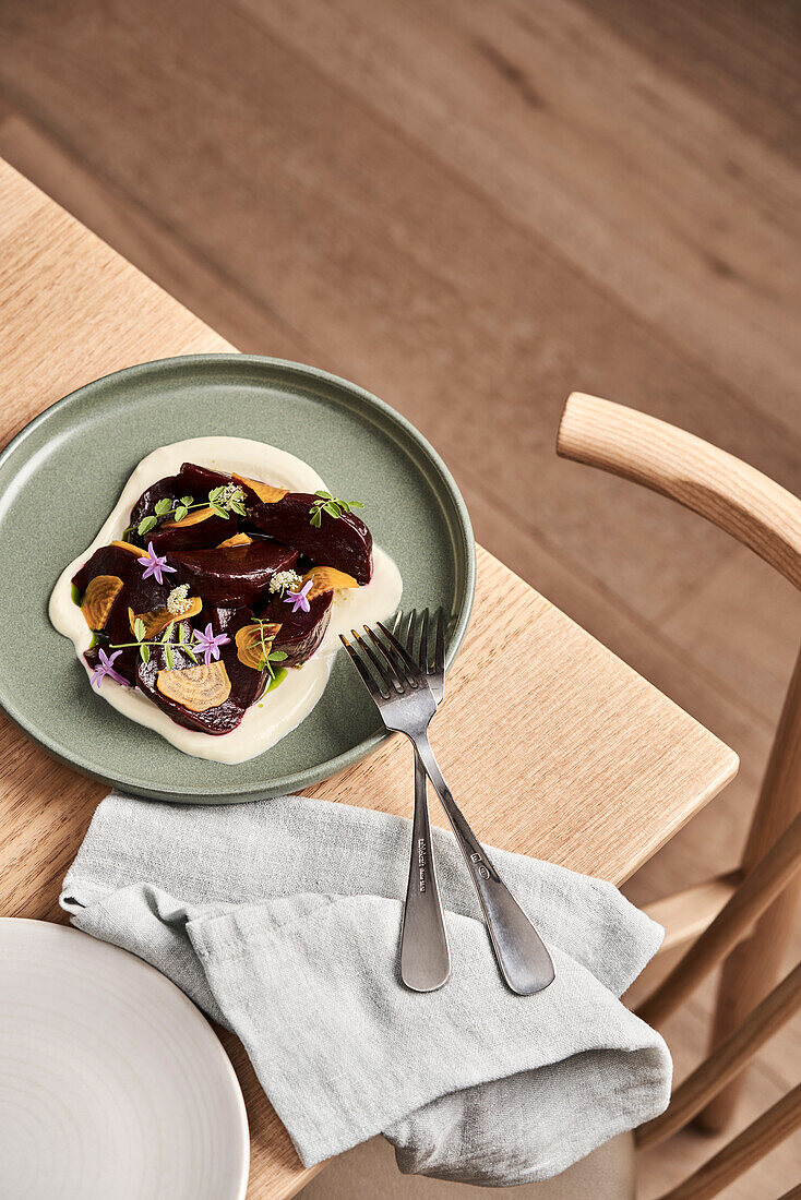 Beetroot carpaccio with cream and edible flowers