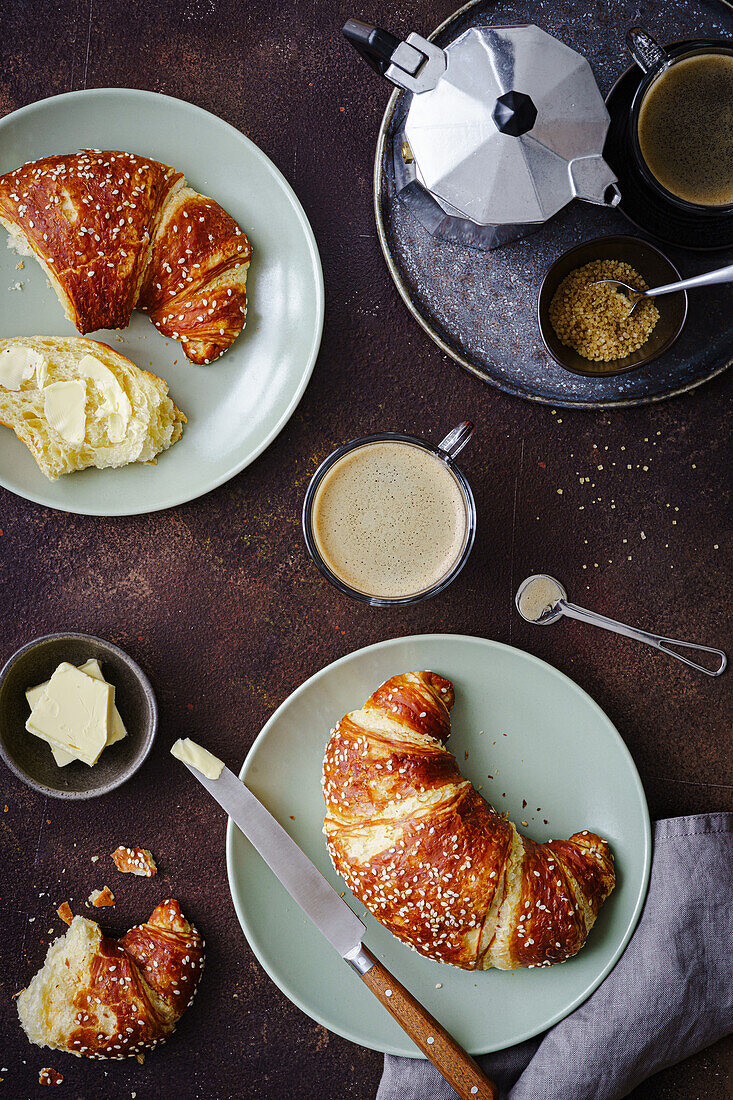 Pretzel croissants with butter and coffee for breakfast