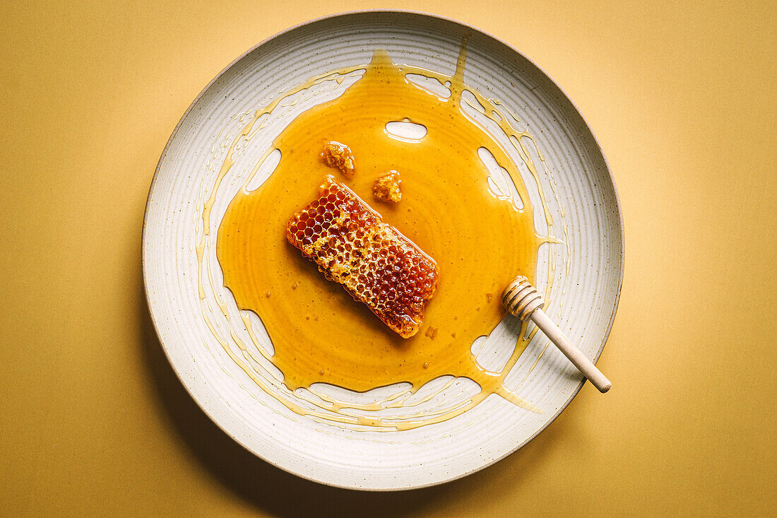 Honeycomb with liquid honey and honey spoon