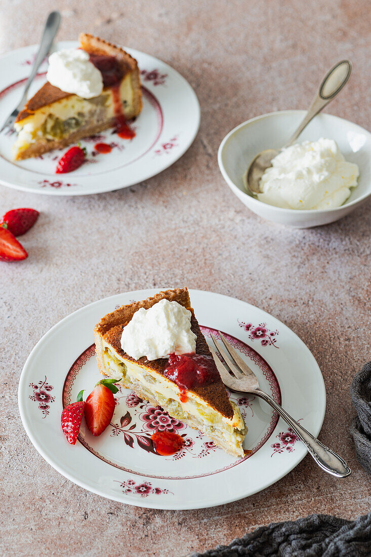 Rhabarberkuchen-Stücke mit Sahne und Erdbeersauce