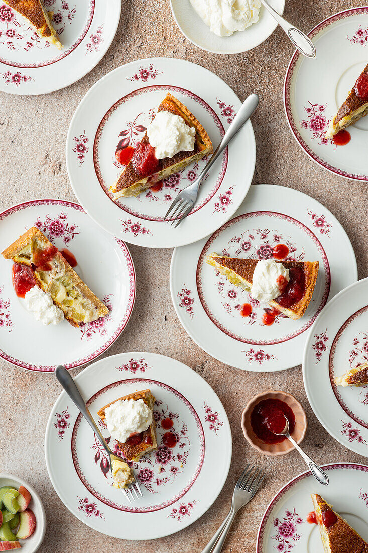 Rhabarberkuchen-Stücke mit Sahne und Erdbeersauce