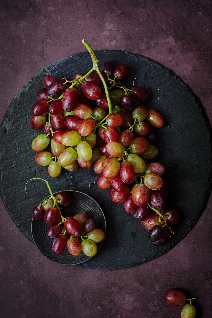 Red grapes on a slate platter