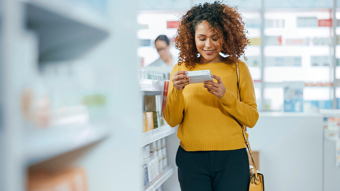 Woman looking at medication in pharmacy