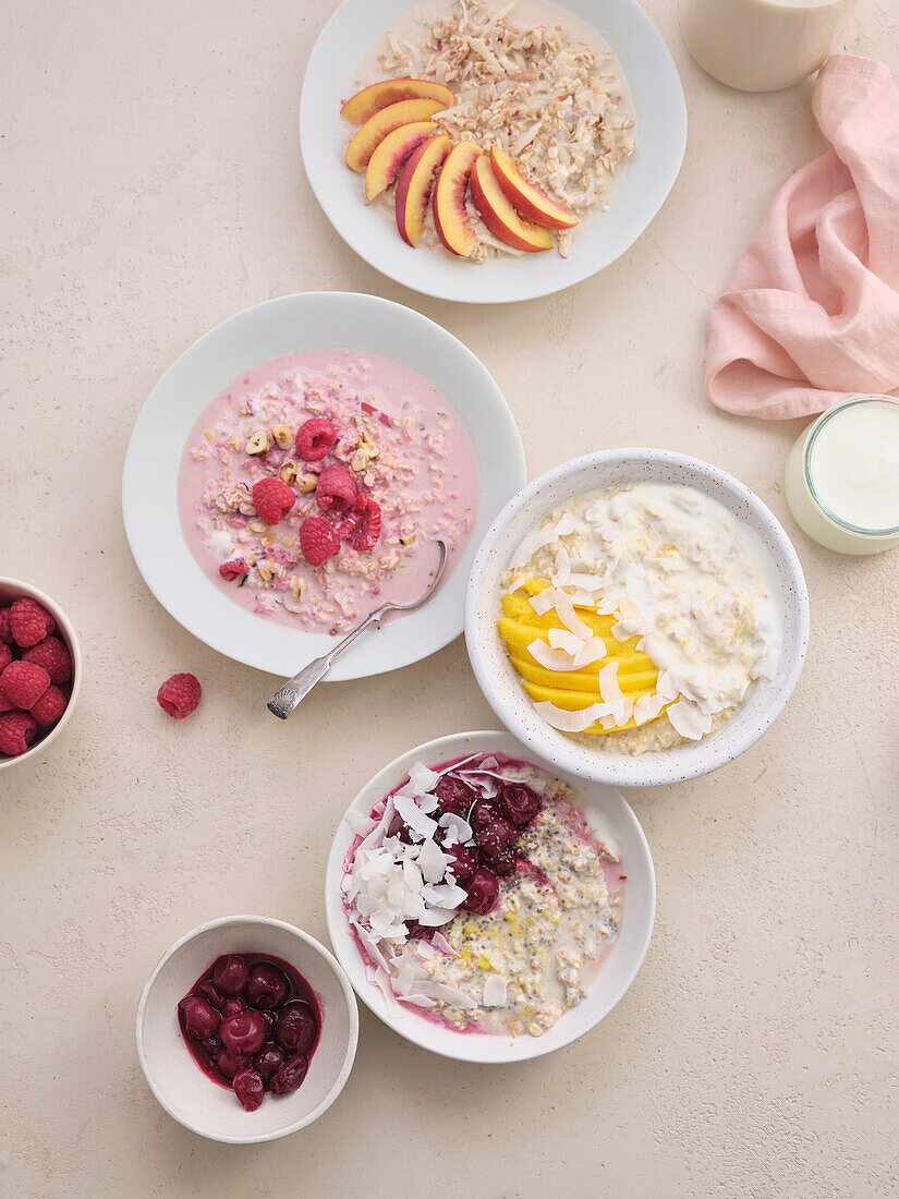 Verschiedene Overnight-Oats mit Früchten, Kokosraspeln und Nüssen