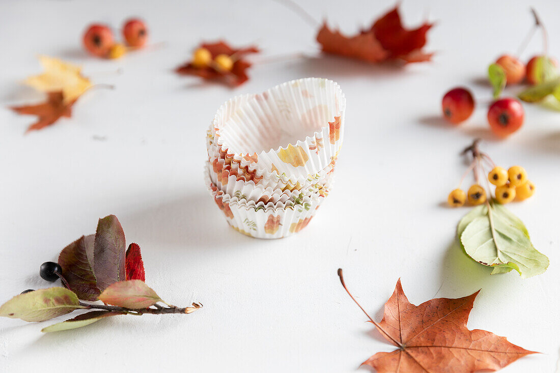 Herbstliche Muffinförmchen mit Ahornblättern und Wildfrüchten