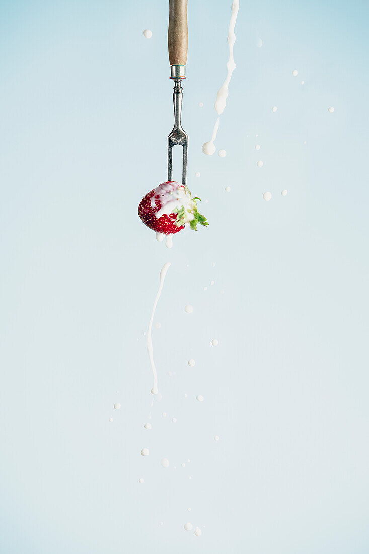 Strawberry on a skewer with dripping cream