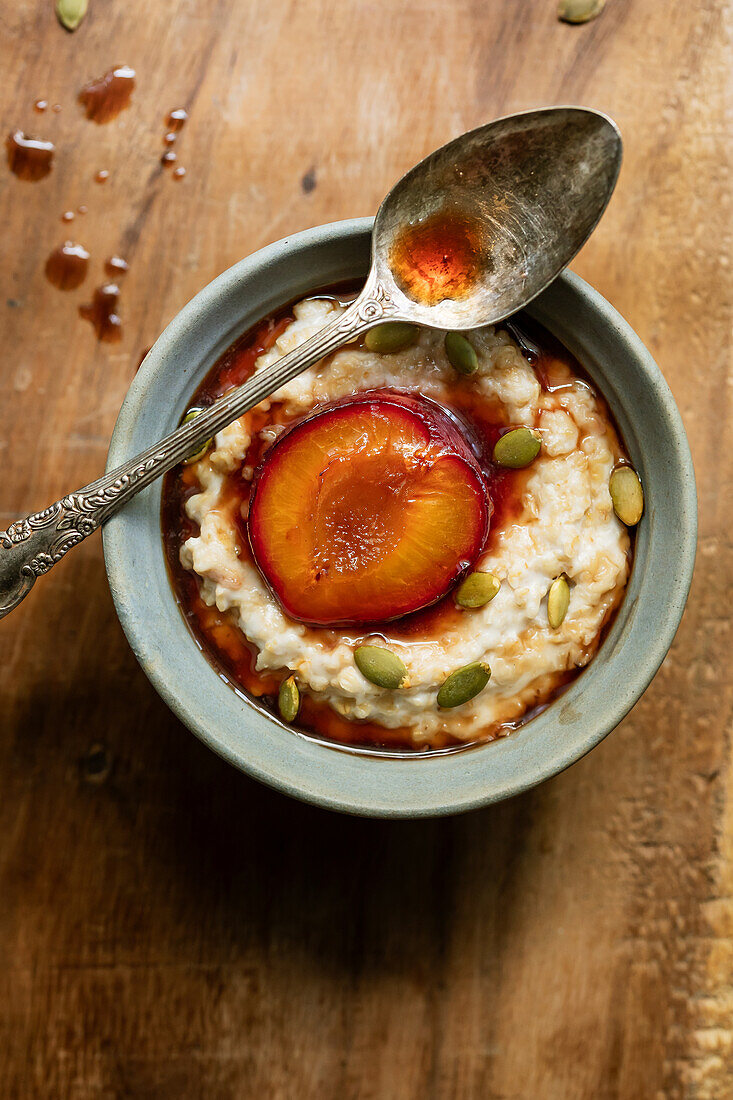 Vegan coconut milk porridge with plum sauce and pumpkin seeds