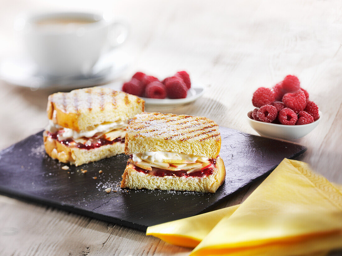 Getoastetes Brioche mit Apfelschnitzen, Himbeermarmelade und Schlagsahne