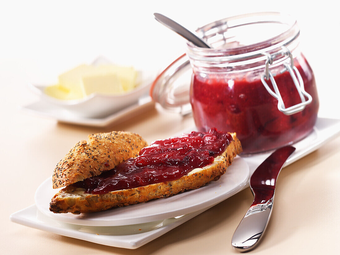 Wholemeal bread roll with damson jam and butter