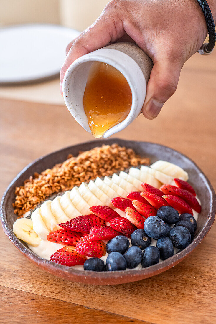 Müsli-Bowl mit Beeren, Banane und Honig