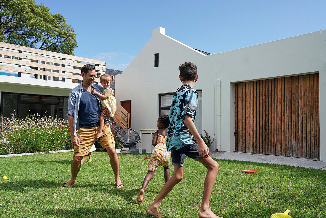 Father with children playing in backyard